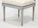 a white chair with a floral upholstered seat on it