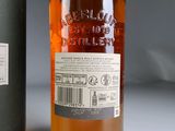 a bottle of alcohol sitting next to a bottle of liquor