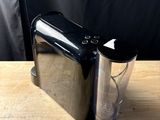 a blender sitting on top of a table next to a cup