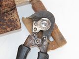 a pair of pliers sitting on top of a piece of wood
