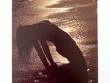 a picture of a woman bending over on the beach