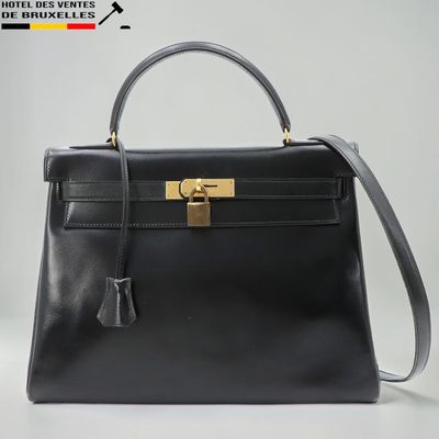 un sac à main en cuir noir muni d'un fermoir doré sur la poignée