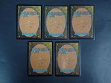 four magic the gathering cards are sitting on top of a table