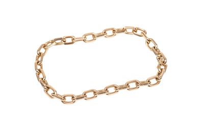 gros plan d'un bracelet en chaîne en or sur fond blanc