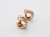 a pair of gold and silver hoop earrings on a white surface