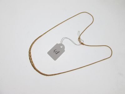 une photo d'un collier en or auquel est accrochée une étiquette