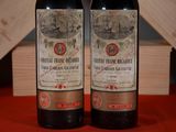 two bottles of wine sitting next to each other on a table