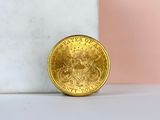 a close up of a gold coin sitting on top of a marble block