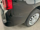 the rear end of a black van parked on the side of the road
