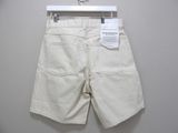 the white shorts are hanging on a hanger on the wall