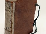 an old book with a handle on it on a white surface