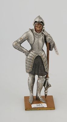 figurine of a man in armor with a sword on a wooden base