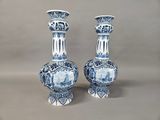 pair of blue and white vases sitting on top of a table