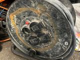 an old reel sitting on the ground next to a pile of wires