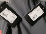 the back of a gray jacket with two tags attached to it