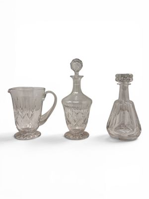 three glass vases and a glass jug sitting next to each other