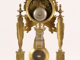 a clock that is sitting on a stand on a white surface