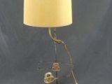 une lampe de table en laiton ancien avec un abat-jour blanc sur fond bleu