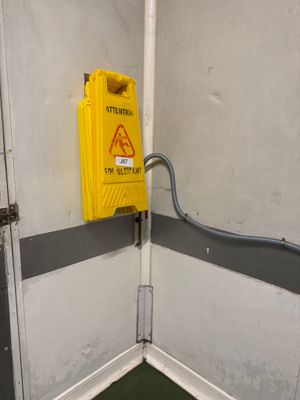 un panneau d'avertissement jaune dans un coin de la pièce