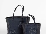 une paire de sacs fourre-tout en toile noire avec des anses en cuir noir