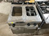 two stainless steel fryers and a stove in a kitchen
