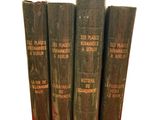 four old books sitting on top of each other on a white surface