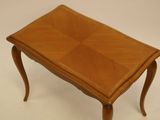 a small wooden table with a leather top on a white background