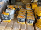 Plusieurs colis de denrées alimentaires sont empilés sur des palettes dans un entrepôt