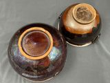 two brown and black vases sitting on a table