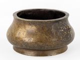 un petit pot en métal orné d'un motif