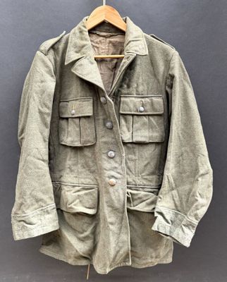 an old jacket hanging on a hanger on a wall