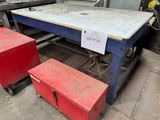 une table sur laquelle est posé un panneau, à côté de deux boîtes rouges