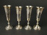 trois vases en argent posés les uns à côté des autres sur une surface noire