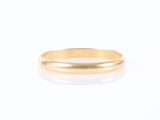 une bague en or à l'anneau fin sur fond blanc