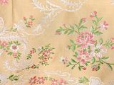 a close up of a table cloth with flowers on it
