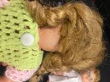 a close up of a doll with a knitted hat on