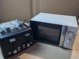 a microwave and a toaster sitting next to each other on the floor