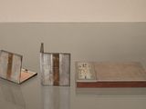 une table en verre sur laquelle se trouvent un livre et une horloge