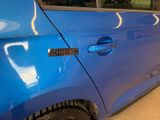 a close up of a blue car with a sticker on it