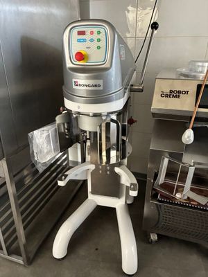 une machine qui se trouve dans une cuisine, à côté d'une étagère