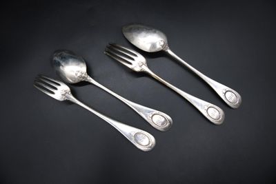 three silver spoons and a fork on a black surface