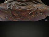 statue of a seated buddha on a black background with a black background
