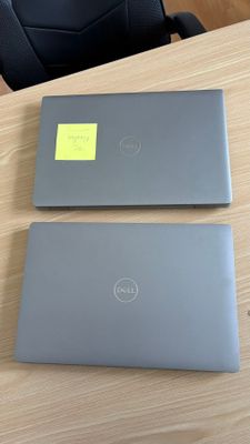 Deux ordinateurs portables sont posés sur une table ; ils sont munis d'un autocollant jaune.