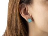 a close up of a woman wearing a pair of earrings