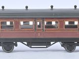 un wagon rouge et noir qui se trouve sur les rails