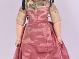 an image of a doll is wearing a pink dress and black shoes