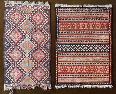 two rugs of different colors and patterns on a brown surface