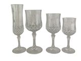 three clear glass goblets and a vase sitting next to each other