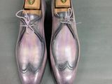 men ' s purple leather shoes with laces on them on a gray surface