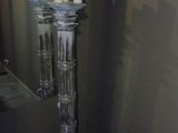 a tall glass vase with candles on top of it